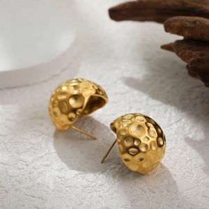 Détail macro de boucles d'oreilles 18K or avec un design martelé en forme de demi-sphère