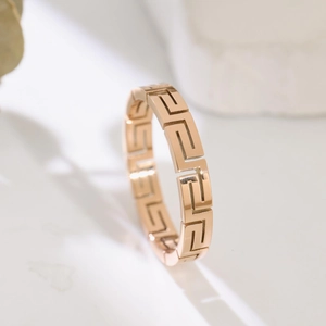 Anello traforato in oro rosa lucido con motivo a greca geometrica in stile minimalista