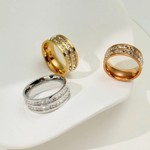 Close-up of three stackable rings in gold, silver, and rose gold with double-row crystals