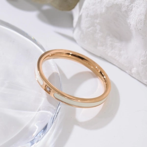 Détail d'une bague en titane or rose avec émail blanc et pierre de cristal brillant
