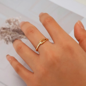 Detail of a minimalist gold U-shaped geometric ring with sparkling pave crystals