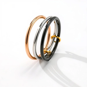 Detailed view of interconnected tri-color rings in rose gold, silver, and black finishes