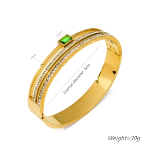 Elegant gold titanium steel bracelet featuring green emerald and rows of white diamonds
