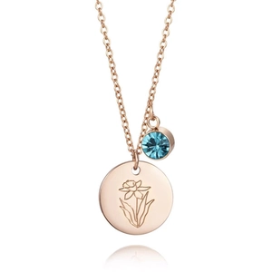 Détail du collier en or rose avec disque fleuri gravé et pendentif en cristal bleu ciel