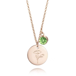 Détail du collier en or rose avec pièce gravée de pavot et pendentif en zircon vert
