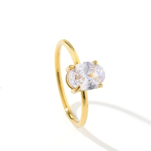 Detailed close-up of a gold oval diamond ring with a four-prong setting and minimalist band