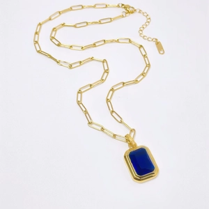 Golden paperclip chain necklace featuring a rectangular deep blue sapphire pendant