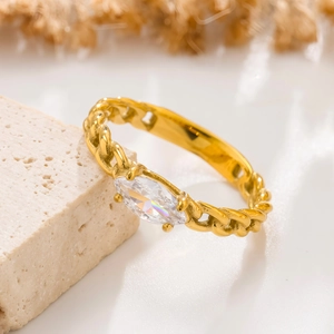Primer plano de un anillo de cadena dorada con circonita marquesa sobre piedra natural