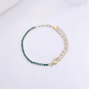 Macro-opname van 18K vergulde roestvrijstalen armband met groene zirkoon en sluiting