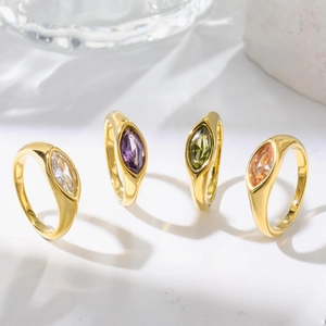 Lot de quatre bagues en acier doré serties de zircons colorés de taille marquise