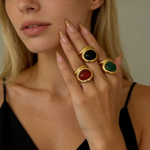 Detail of vintage gold-plated wide rings with malachite and colorful oval gemstones