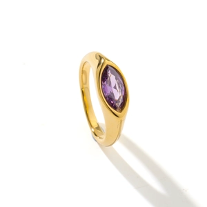 Vue macro d'un anneau doré avec une pierre violette marquise et des détails élégants