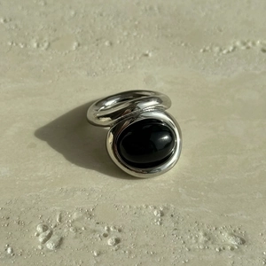 Detail of vintage signet ring with oval black onyx gemstone in silver titanium steel