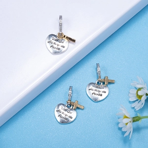 Pendentif cœur religieux avec gravure en argent et croix dorée sur fond bleu élégant