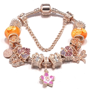 Rosegoldenes Schlangenarmband mit Kristall-Schmetterling und Fruchtanhängern auf Weiß