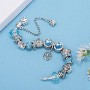 Detalle de pulsera de plata con cuentas de cristal azul y colgante del árbol de la vida