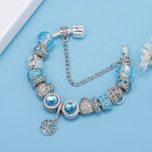 Detalle macro de pulsera de plata S925 con cuentas de cristal azul y colgante árbol de vida