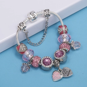 Detail of beaded snake chain bracelet with pink rose charm and engraved love heart pendant
