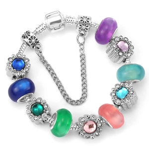 Versilbertes Schlangenarmband mit bunten Kunstharzperlen und Gänseblümchen auf weißem Hintergrund