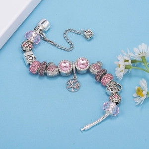Vista de cerca de la pulsera plateada con cuentas de cristal rosa y varios dijes