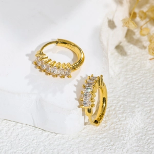 Minimalist gold hoop earrings featuring vertical baguette-cut crystals on textured stone