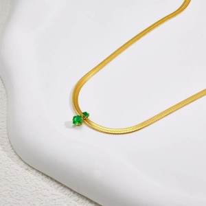 Elegante goldene Schlangenkette mit funkelnden quadratischen und runden grünen Edelsteinen