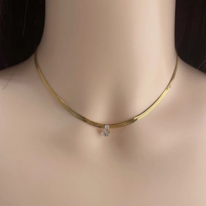 Elegante goldene Schlangenkette mit rundem Zirkonia-Anhänger an einem Model präsentiert