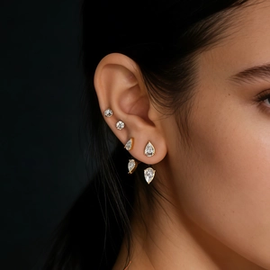 Close-up of golden zircon ear jacket earrings featuring drop-cut stones on a model