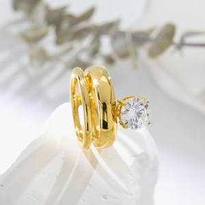 Detailed view of two-piece gold titanium rings with a large round zircon on white stone