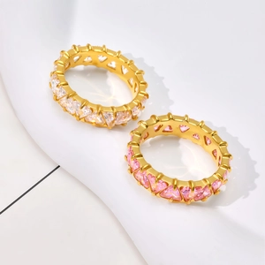 Close-up of gold eternity rings with heart-shaped pink and clear zirconia stones