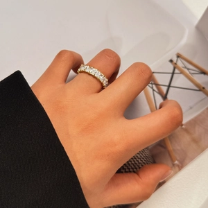 Close-up of a gold titanium ring with triangle-cut zircons worn on a hand