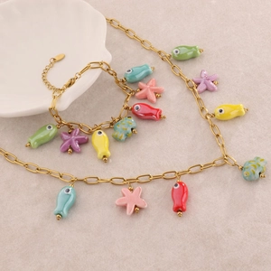 Gold ocean themed necklace and bracelet set with colorful fish and starfish charms