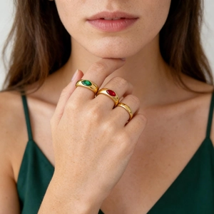 Détail de trois bagues en titane plaqué or 18K avec gemmes marquises portées par un mannequin
