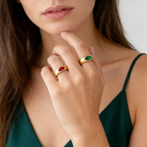 Détail de bagues en acier titane or 18K avec cristaux marquise rouges et verts