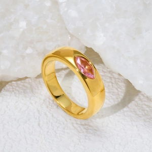 Détail d'une bague dorée 18K sertie d'une gemme marquise rose sur cristal blanc