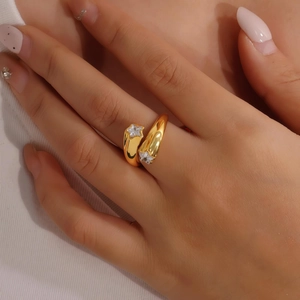 Detail van een verstelbare gouden roestvrijstalen ring met zirkoonsterren aan vinger
