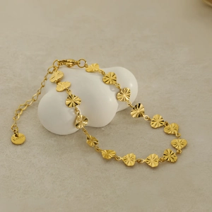 Elegant gold stainless steel heart pendant bracelet with radial engraving on white stand