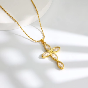 Detail van een gouden kruis hanger ketting met marquise kristallen en een kogelketting