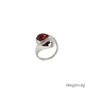 Detail of silver drop-shaped ring with red gemstone and minimalist wrap design