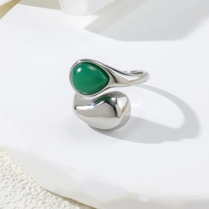Detailed view of silver irregular open ring with green teardrop stone and metallic drop