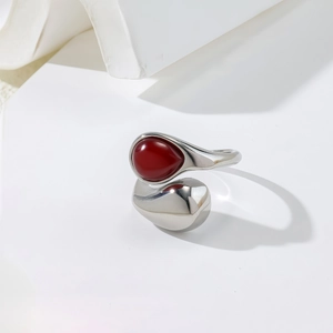 Adjustable silver steel ring with irregular red teardrop gemstone and metal drop accent