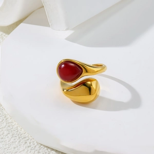 Macro detail of a gold teardrop ring with a red stone on geometric display blocks