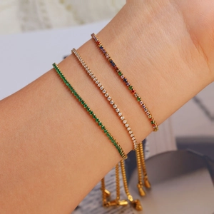 Drie gouden tennisarmbanden met smaragdgroene, witte en kleurrijke zirkoonkristallen