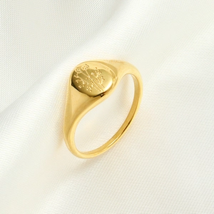 Macro detail of a gold titanium steel signet ring with engraved floral flower patterns