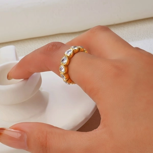Detail of gold-plated ring featuring a full circle of heart-cut cubic zirconia stones