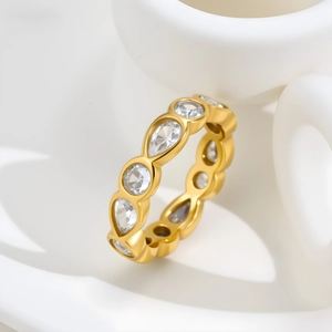 Macro detail of gold eternity ring featuring alternating pear and round-cut cubic zirconia