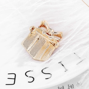 Back view of gold gift box brooch with safety pin fastener and frosted metal texture