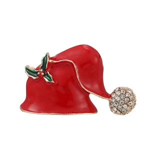 Red Christmas hat brooch with rhinestones and green holly leaves on white background
