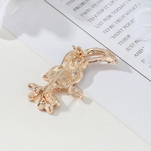 Exquisite gold bird brooch showing fine feather texture and classic pin closure on back