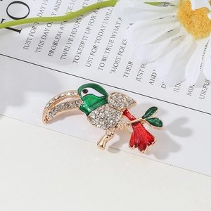 Elegant rhinestone bird brooch with green and red enamel in a luxury gold finish
